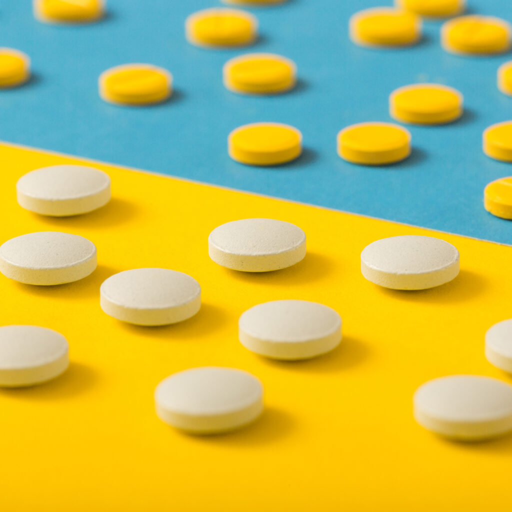 scattered-pills-yellow-blue-background-1024x1024-1